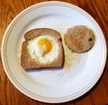 Overhead view of fried egg in bread on a round plate. Comfort breakfast food.