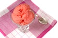 Overhead view of a glass of cherry sherbet on a red and white na