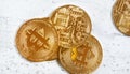 Overhead view, golden commemorative btc - bitcoin cryptocurrency - coins scattered on white stone board, closeup detail