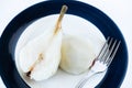 Overhead view of a halved, peeled red battler pear on a plate. Organic and natural products, healthy and wholesome food