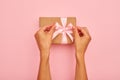 Hands tying pink bow on a present box Royalty Free Stock Photo
