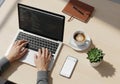 Person coding on a laptop with coffee and a notebook Royalty Free Stock Photo
