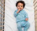 Overhead view of a happy baby boy lying in a crib Royalty Free Stock Photo