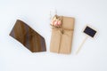 Overhead view homemade DIY wrapped present boxes with mini blank space chalkboard and necktie on white background.