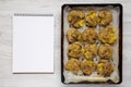 Overhead view, homemade garlic thyme smashed potatoes on a tray, blank notepad. Flat lay, overhead, from above. Copy space