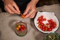 Overhead view of a housewife in black chef& x27;s apron pickling ripe and juicy cherry tomatoes at home kitchen Royalty Free Stock Photo