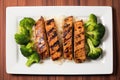 overhead view of juicy teriyaki-marinated tofu steaks on a white plate