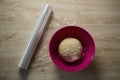 Overhead view of kneaded dough in pink bowl