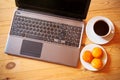 Overhead view of laptop, fresh cakes and white cup of coffee