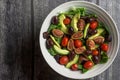 Overhead view of a large white bowl of fresh salad on wood