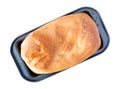 Overhead view of a loaf of homemade bread in a gray metal pan at an angle isolated on a white background