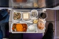 Overhead view of inflight airplane Asian food set meal served consisting rice and spicy chicken, appetizer, dessert, bun Royalty Free Stock Photo