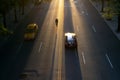 Overhead view of man riding a bike through streets of New York City with the light of sunset in the background casting long Royalty Free Stock Photo