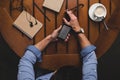 overhead view of man using smartphone with instagram website while sitting at table with coffee