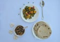 Overhead view of matar paneer veg, mashroom soup and roti Indian food over white background, with copy space