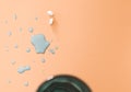 Overhead view of medication tablets on pastel orange surface with water splash and copy space