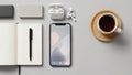 Overhead view of a modern workspace with a smartphone, open notebook, pen, wireless earbuds, and a cup of coffee on a Royalty Free Stock Photo