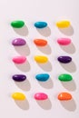 Overhead view of multi colored candies in a row over white background