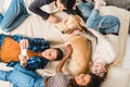 overhead view of multicultural teens lying on bed and taking selfie