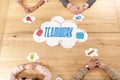 Overhead view of multiracial business people at wooden table with blank paper clouds,