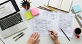 Overhead view of a person s hands sketching a website layout on paper with a laptop and coffee Royalty Free Stock Photo
