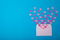 Overhead view of pink hearts coming out from white envelope on blue background, copy space Royalty Free Stock Photo