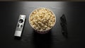 Overhead view of popcorn remote control and 3D glasses on a dark surface Royalty Free Stock Photo