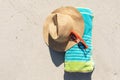 Overhead view of red sunglasses, sunhat and rolled beach towel on sunny sand beach