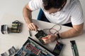 overhead view of repairman using multimeter while testing hard disk drive