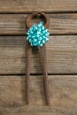 Overhead view of rusty tool decorated with blue ribbon on table