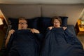 Overhead view of screaming scared old couple in bed