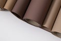 An overhead view of several rolls of paper in various brown and beige tones, laid on a white background. Royalty Free Stock Photo