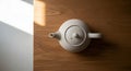 Minimalist White Teapot on a Wooden Table with Natural Light Royalty Free Stock Photo