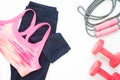 Overhead view of sport bra, fitness legging and sport equipments on white background