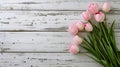 Overhead view of a springtime pink tulips on white weathered wooden boards, top view
