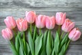 Overhead view of a springtime pink tulips on white weathered wooden boards, top view