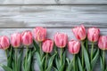 Overhead view of a springtime pink tulips on white weathered wooden boards, top view