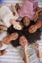 Overhead View Of Teenage Friends Lying On Bed Together