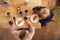 Overhead View Of Two Female Friends In Coffee Shop Meeting Up In Socially Distanced Way