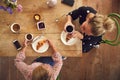 Overhead View Of Two Female Friends In Coffee Shop Meeting Up In Socially Distanced Way