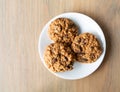 Top view of homemade oatmeal raisin cookies on a white plate atop a table illuminated with natural light Royalty Free Stock Photo