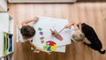 Overhead view of two toddler children painting with water colour