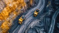 Overhead view of two yellow dump trucks on winding quarry roads Royalty Free Stock Photo
