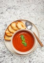 Overhead view of vegan tomato soup on a granite surface