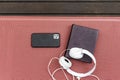 overhead view of white headphones, vintage book and smartphone on a deck hammock