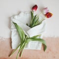 Overhead view of white knitted sweater and bouquet of fresh tulips Royalty Free Stock Photo