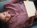 Overhead View Of Woman Lying On Sofa At Home Watching Movie On Digital Tablet Royalty Free Stock Photo