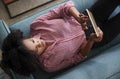 Overhead View Of Woman Lying On Sofa At Home Watching Movie On Digital Tablet Royalty Free Stock Photo