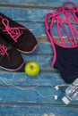 Overhead view of womenswear with Granny Smith apple and bottle by headphones