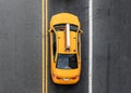 Overhead view of yellow New York City taxi driving between the lines on the road